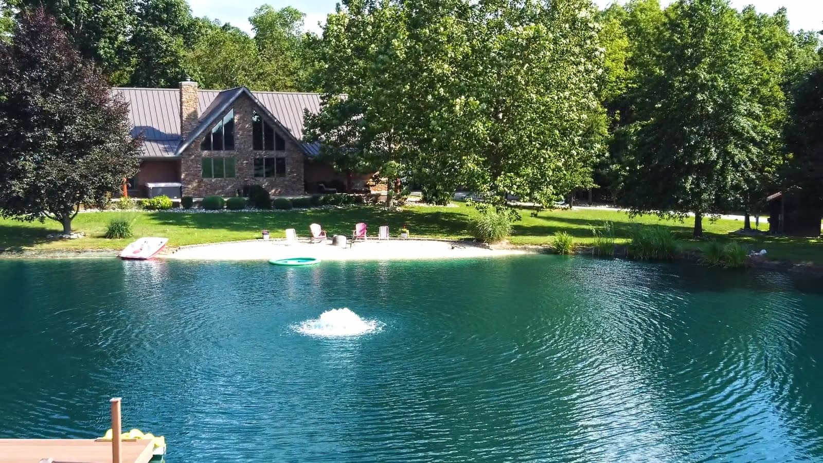 Drone aerial over the swimming pond and home at 150 E Township Rd 42
